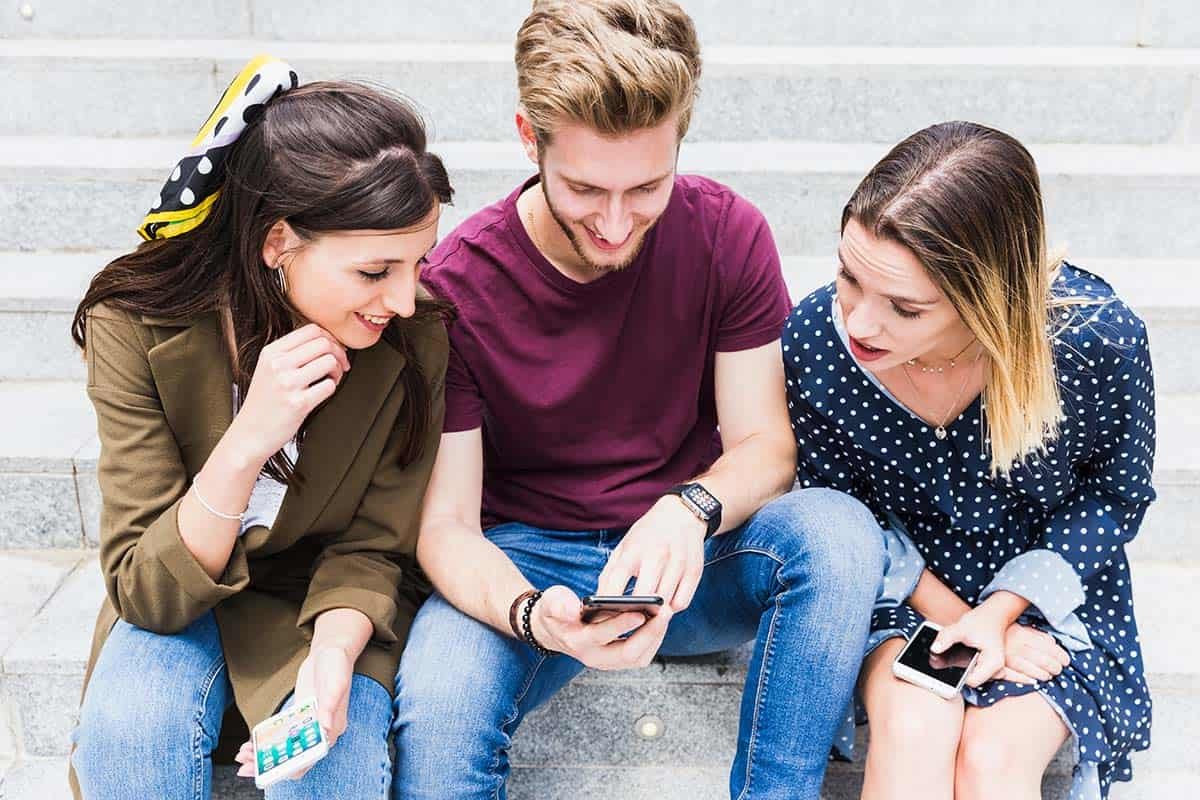 3 people looking at a refurbished iphone