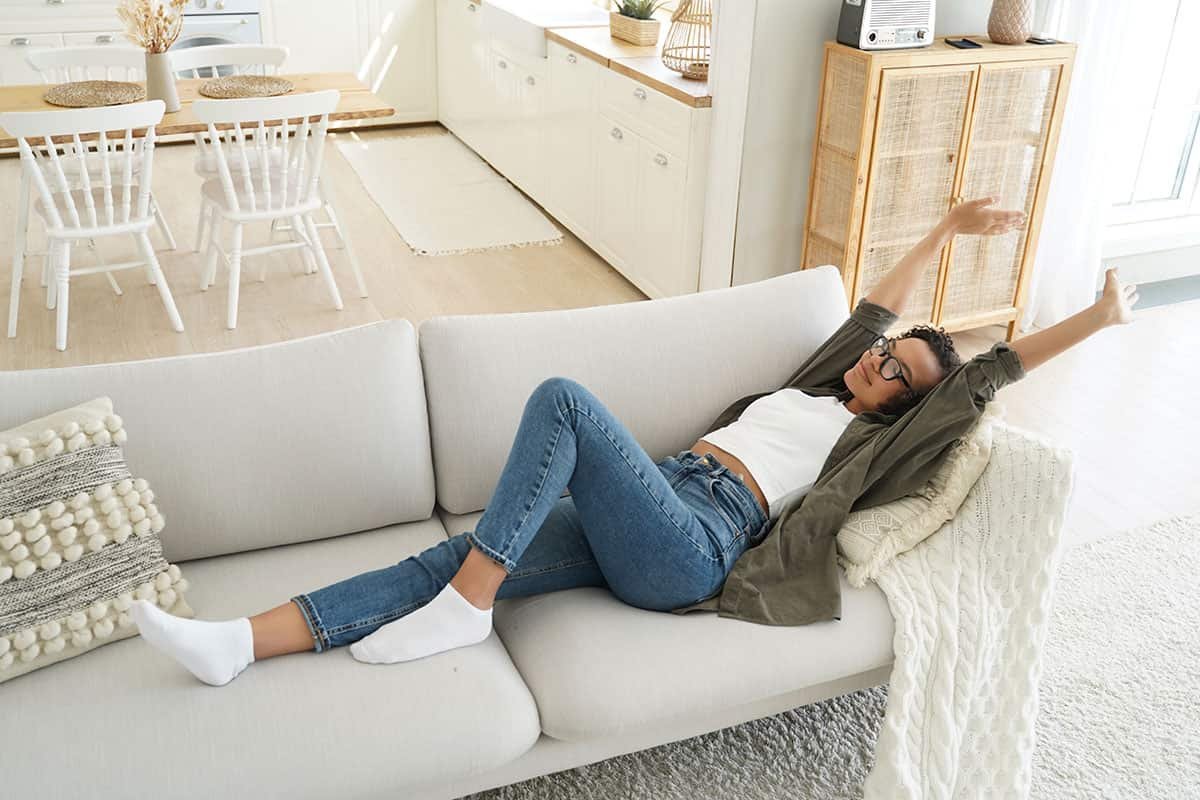 Girl laying down on a sofa in the home