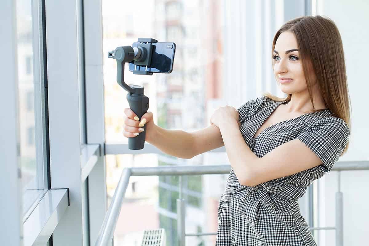 Lady using a gimbal for her smartphone to film her chatting